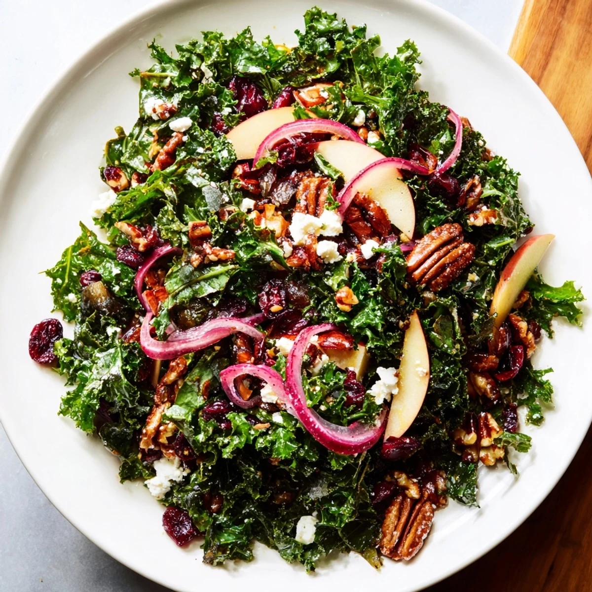 A colorful bowl of Winter Kale Salad with a maple-Dijon dressing, ready to enjoy.