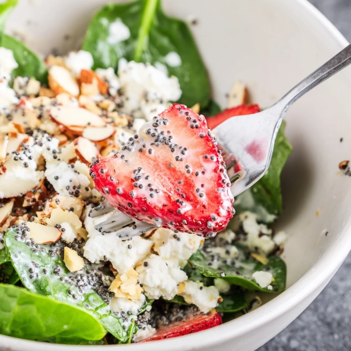 Glistening poppy seed dressing coats tender baby spinach and sliced strawberries in a refreshing Strawberry Spinach Salad bowl.