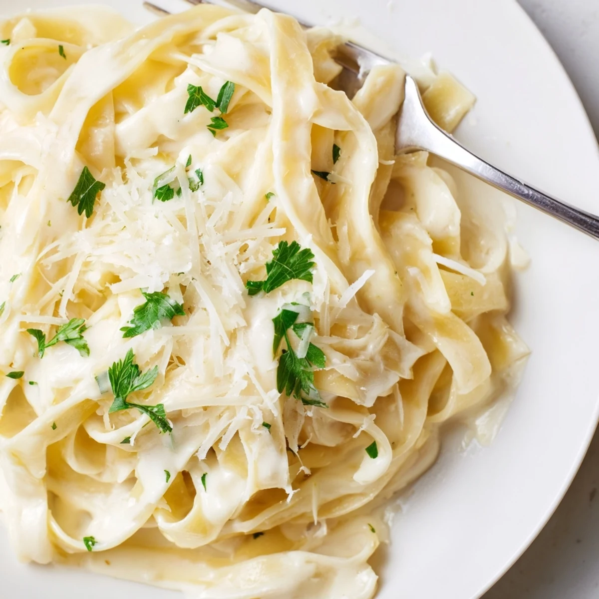 Steaming bowl of Creamy Garlic Pasta with Parsley served alongside a crisp green salad and a glass of white wine.