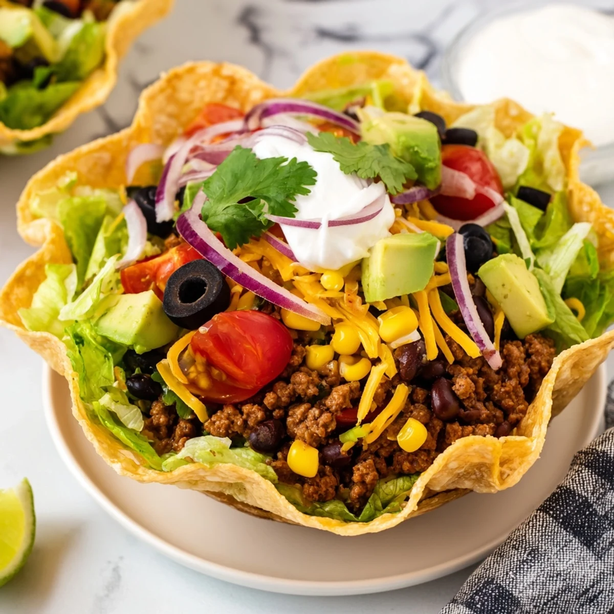 Freshly prepared Beef Taco Salad with Homemade Tortilla Bowl showcases crisp romaine, cherry tomatoes, and black olives topped with savory ground beef and zesty salsa.
