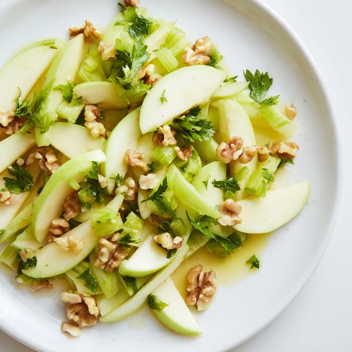 A vibrant bowl of homemade Apple and Celery Salad with crunchy walnuts, parsley, and a tangy honey-Dijon vinaigrette.  
