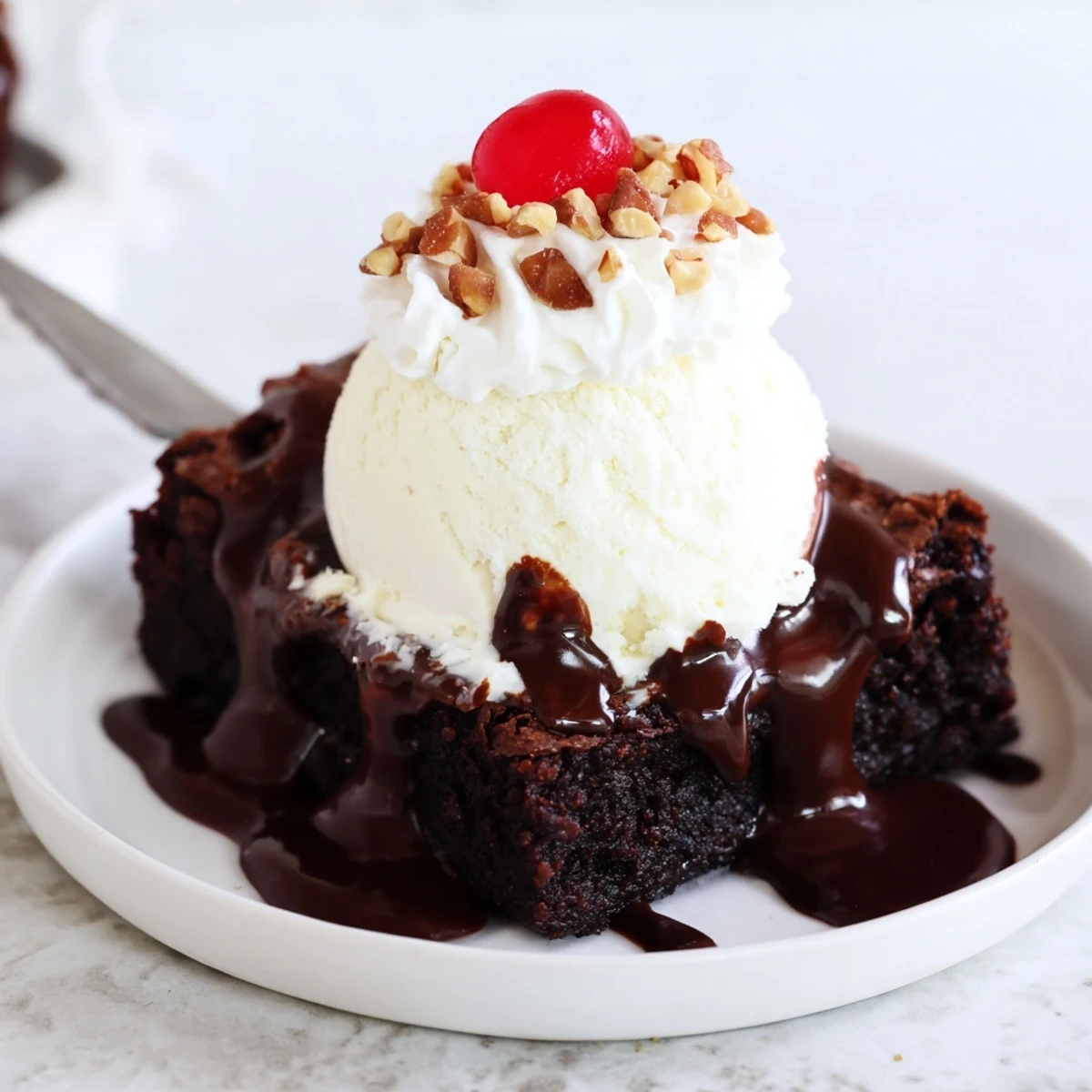 Decadent Chocolate Brownie Sundae served in a glass bowl, showcasing layers of fudgy brownie and velvety sauce.