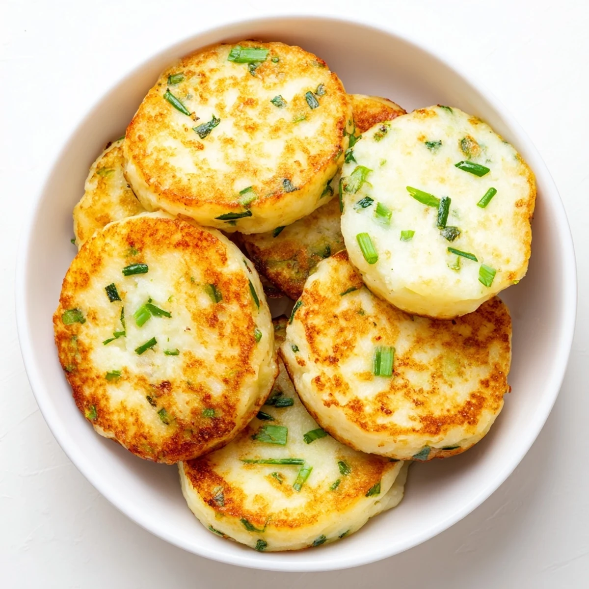 A close-up of warm Irish Potato Cakes with Scallions highlights the soft, creamy texture inside.