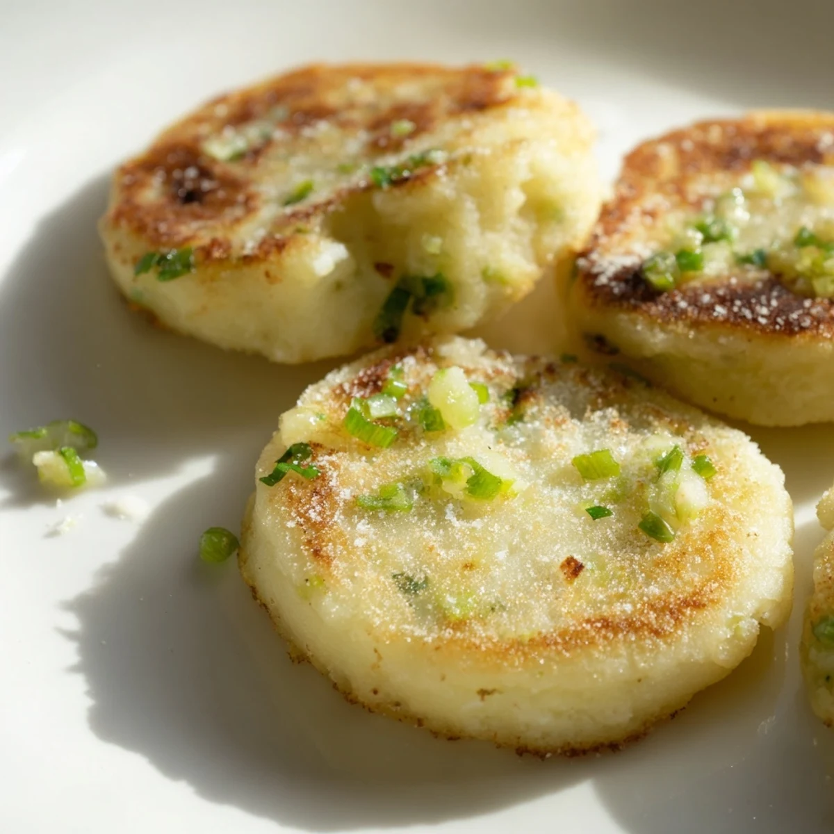 Golden, pan-fried Irish Potato Cakes with Scallions served warm beside a poached egg for breakfast.