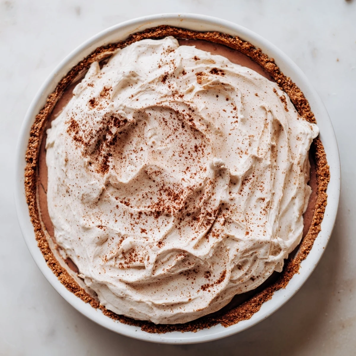 The Keto Cold Brew Coffee Pie features a creamy filling and a crisp almond flour crust, garnished with coffee beans for a bold dessert.