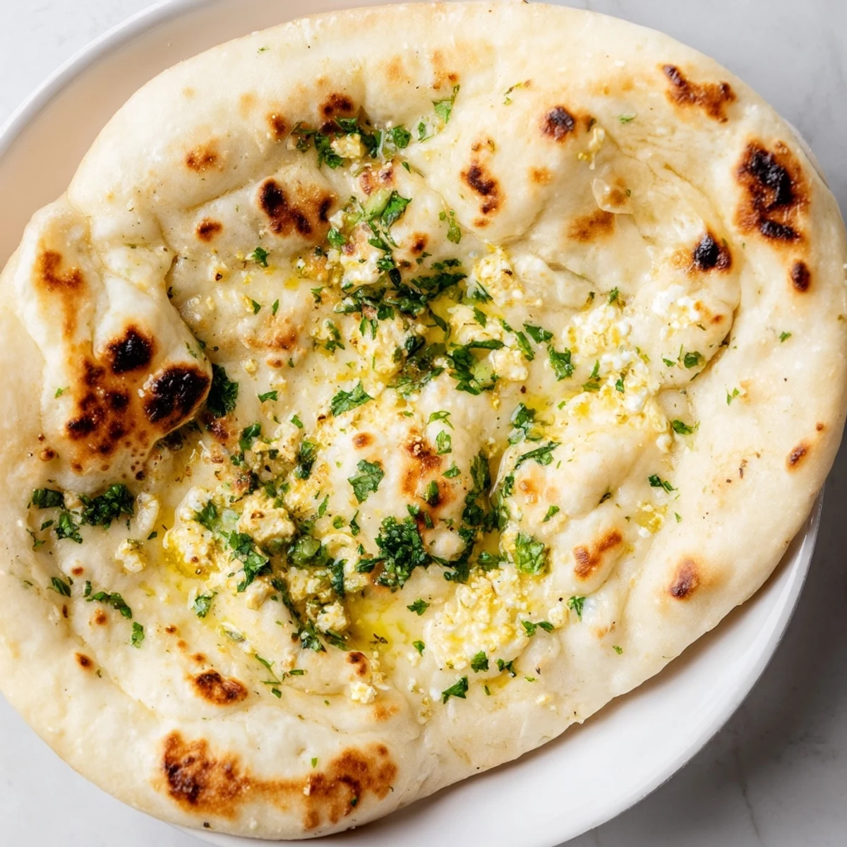 Warm Cottage Cheese Garlic Naan torn open to reveal creamy cottage cheese filling, ideal for scooping up dal.