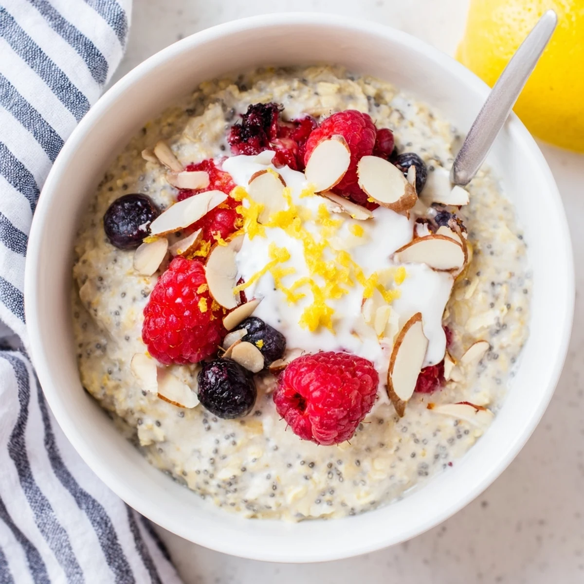 A close-up view of chilled Vegan Lemon Poppy Seed Overnight Oats with glistening lemon zest and crunchy poppy seeds.