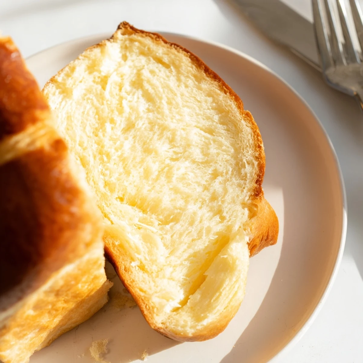 A close-up of sliced Milk Brioche reveals a tender, pillowy crumb perfect for French toast or breakfast toast.