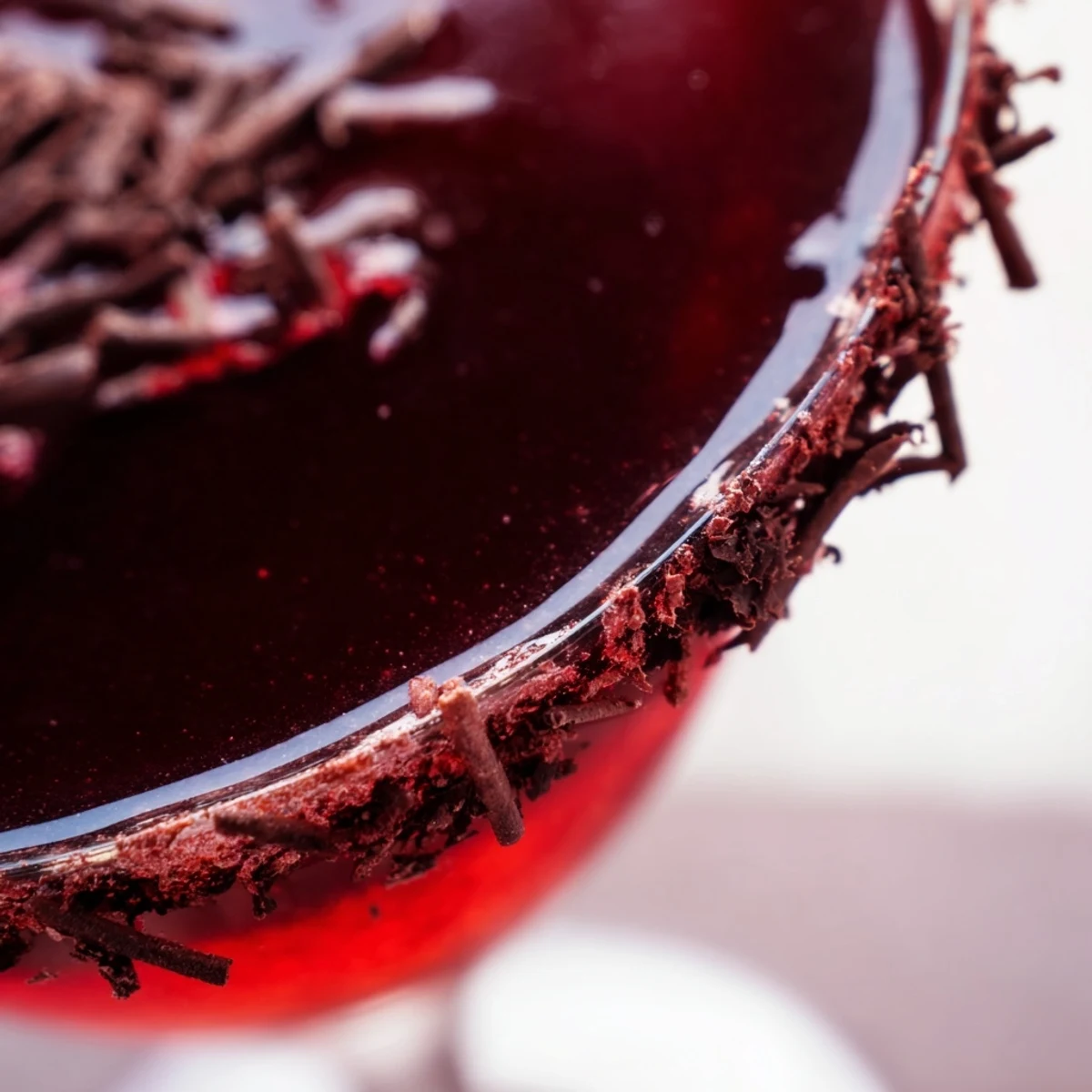 The Decadent Red Velvet Martini shows a creamy red hue with a cream cheese frosting rim and cocoa dust.