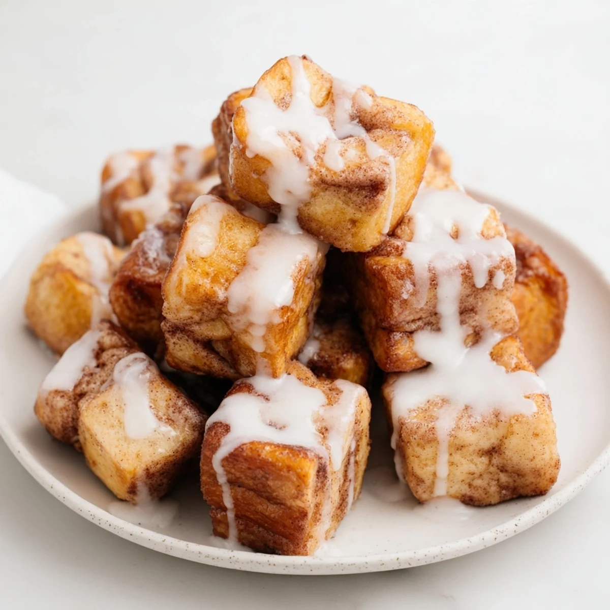A close up view of bite sized Cinnamon Roll French Toast Bites coated in cinnamon sugar.