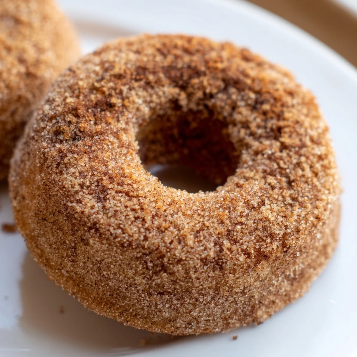 Golden Delicious Baked Cinnamon Sugar Donuts You Cant Resist glistening with sparkling sugar on a wire rack for breakfast.