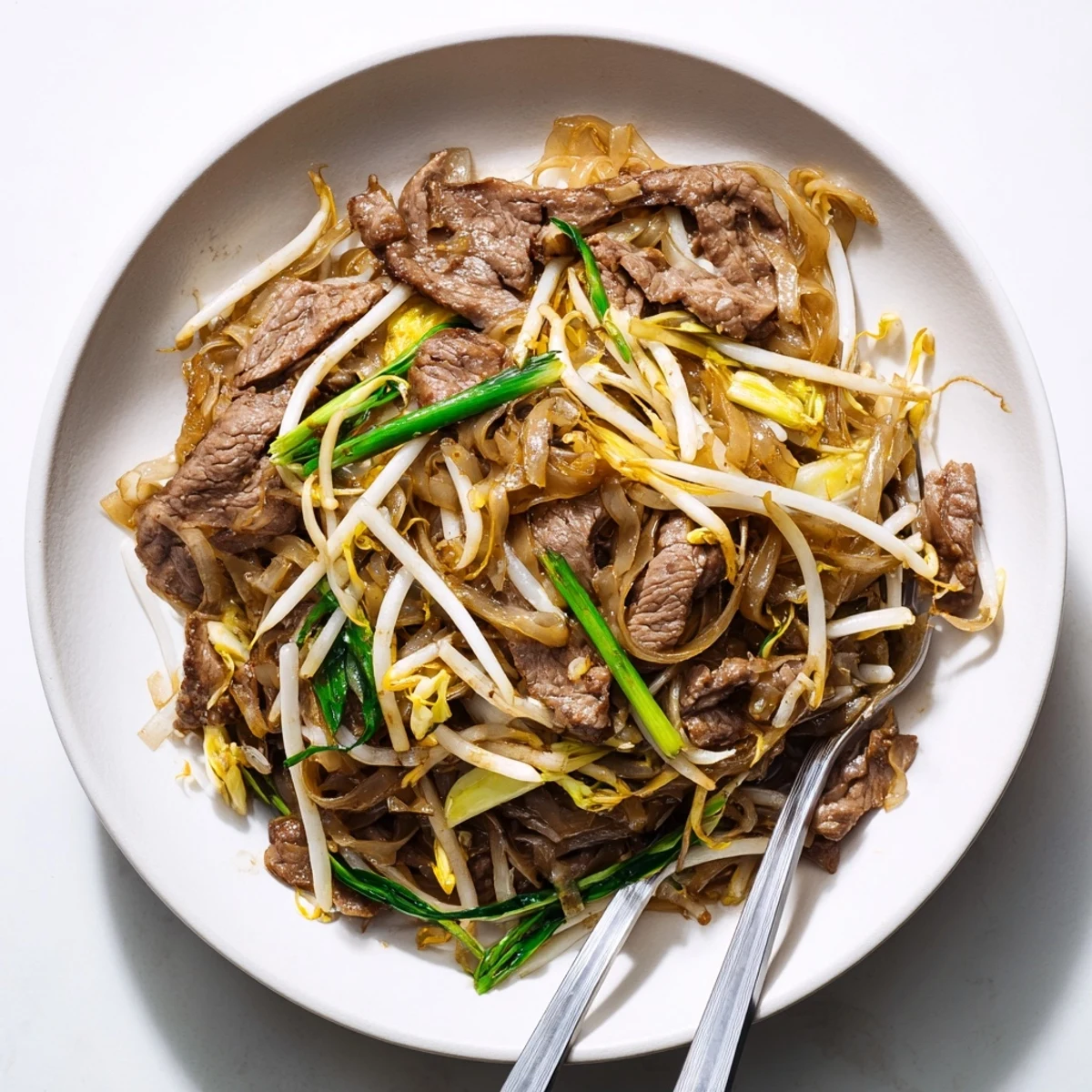 Wok-seared Beef Chow Fun with tender beef slices and charred wide rice noodles in savory sauce.
