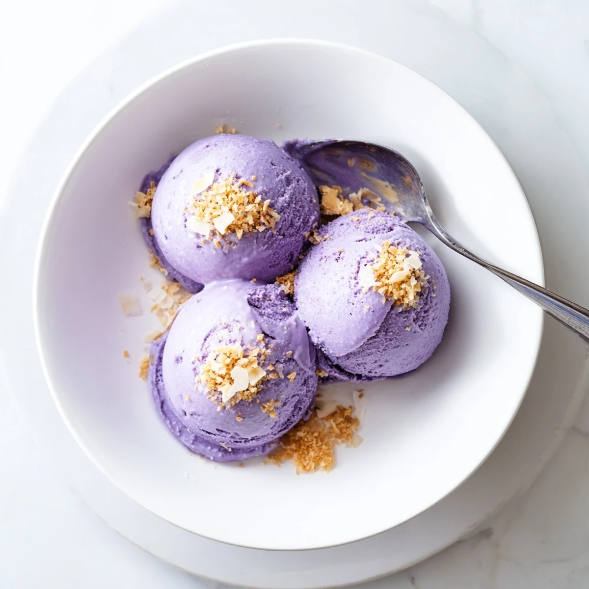 Freshly frozen ube ice cream with a smooth, creamy texture, scooped into a dessert dish ready to be served.
