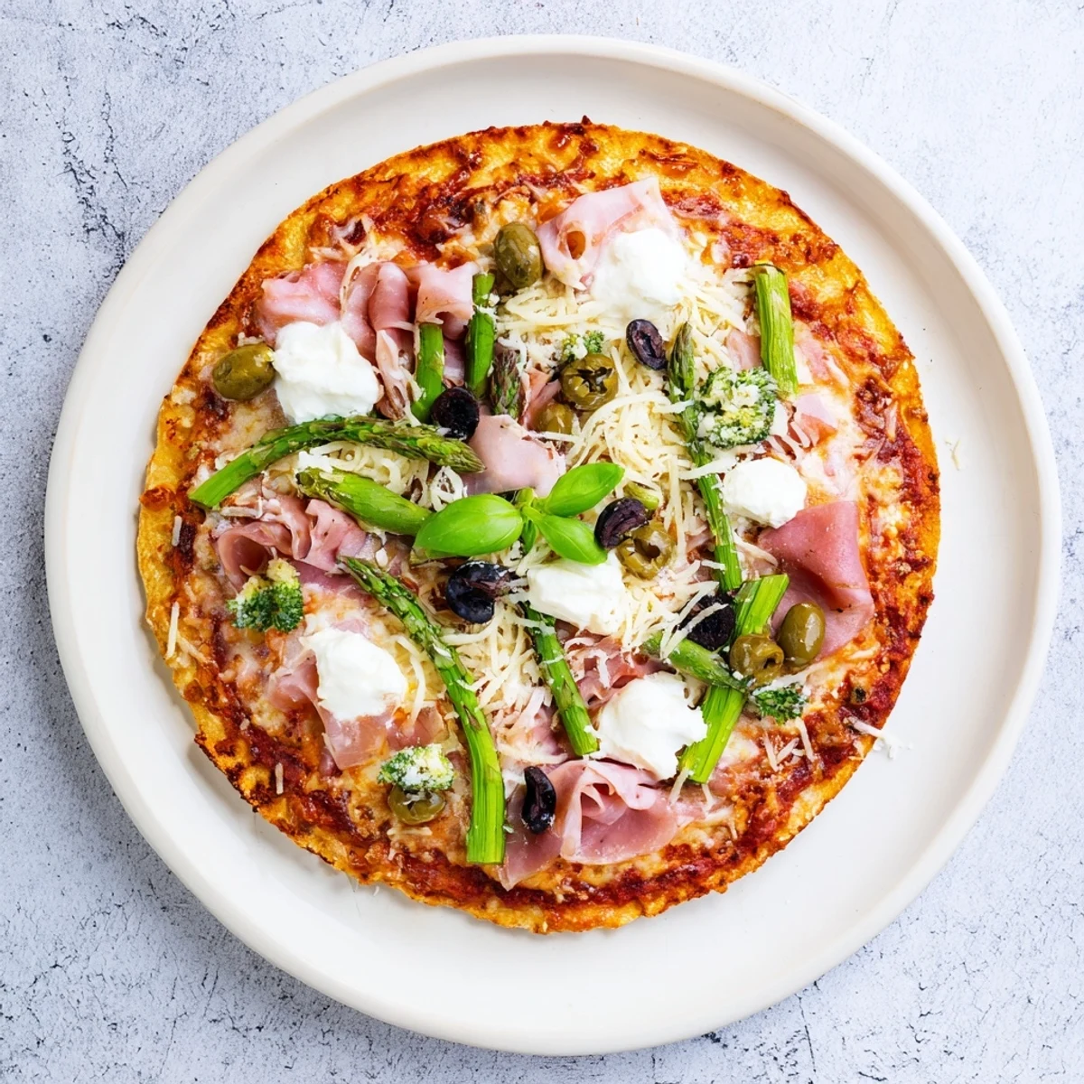 Rustic Italian-style Ham, Olive, Asparagus, and Ricotta Pizza on a wooden board, garnished with fresh basil and drizzled with olive oil for a savory, comforting meal.
