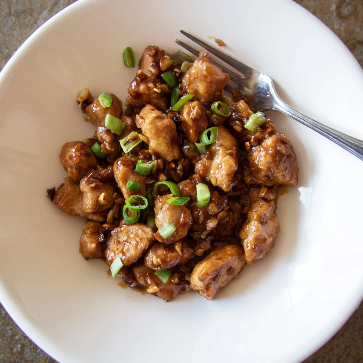 Golden glazed Mongolian chicken pieces coated in thick brown sugar soy sauce