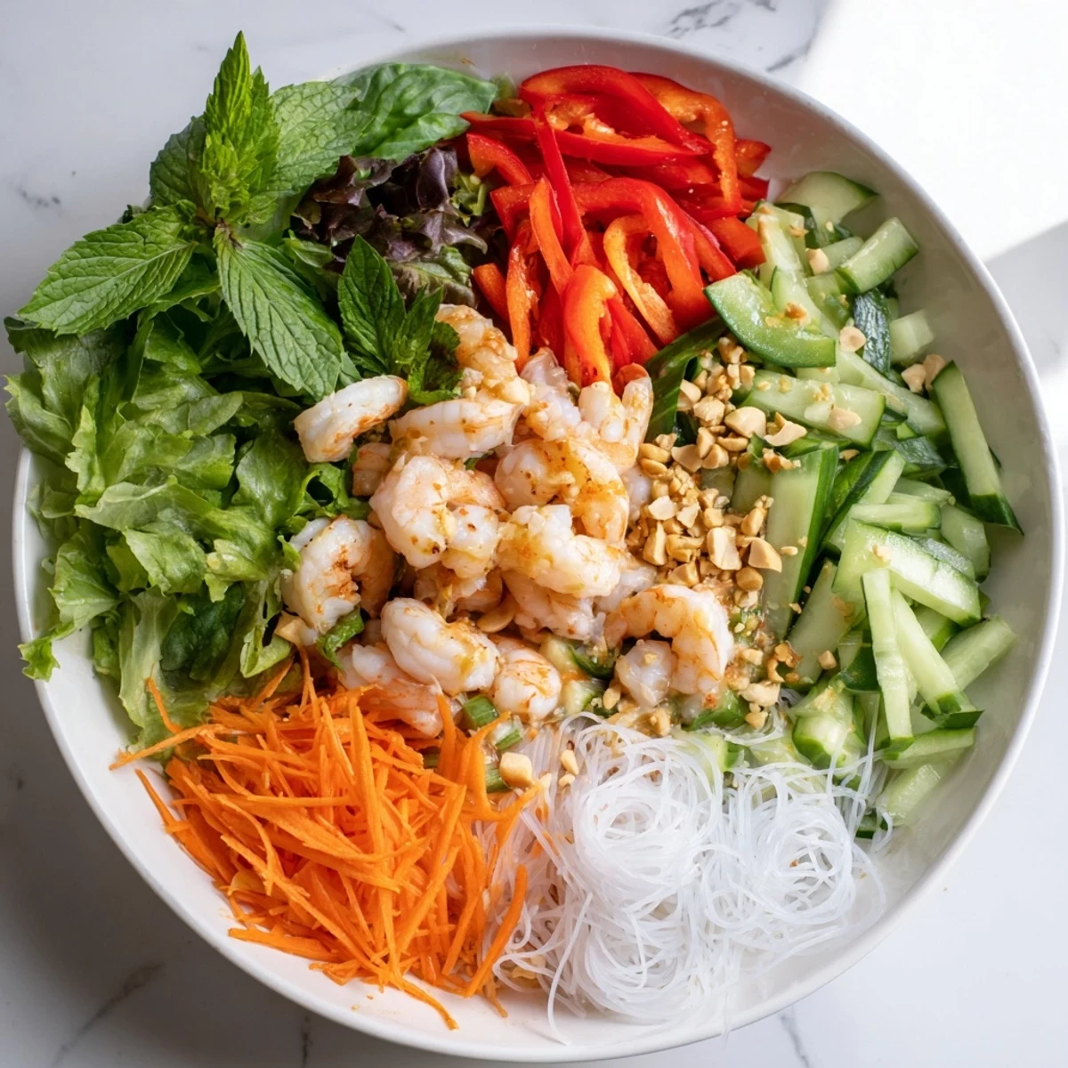 Deconstructed spring roll salad with julienned vegetables, fresh herbs, peanuts, and tangy spicy ginger dressing