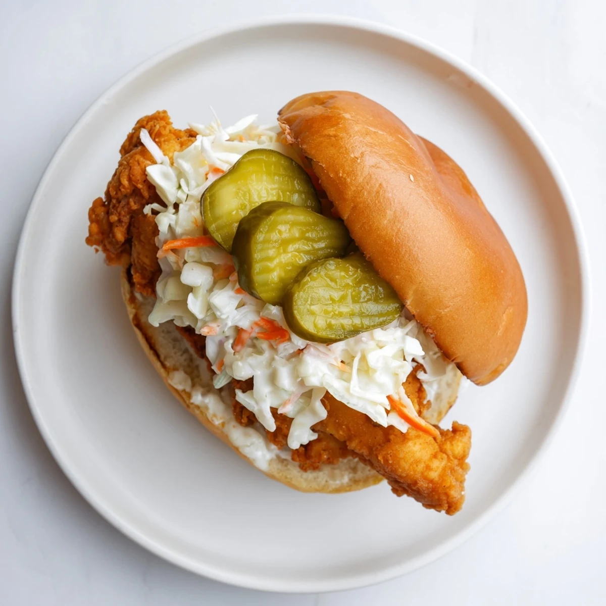 Golden Southern fried chicken burger topped with creamy coleslaw and crisp dill pickle slices