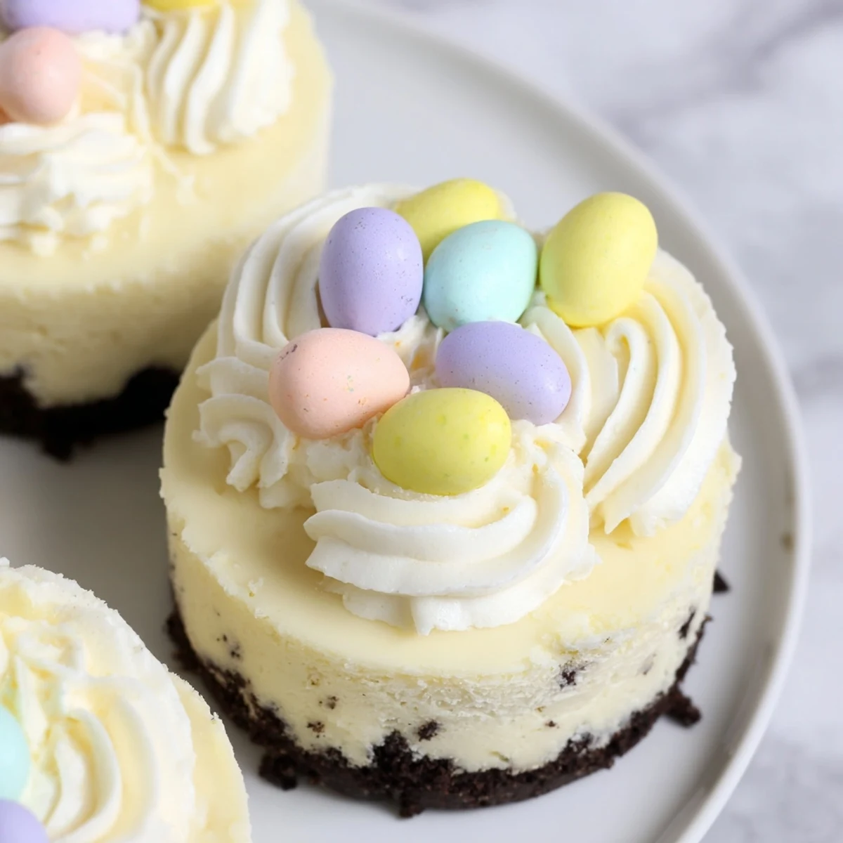 Creamy Easter Cadbury Mini Cheesecakes feature crunchy chocolate crust and festive candy egg garnish for spring desserts