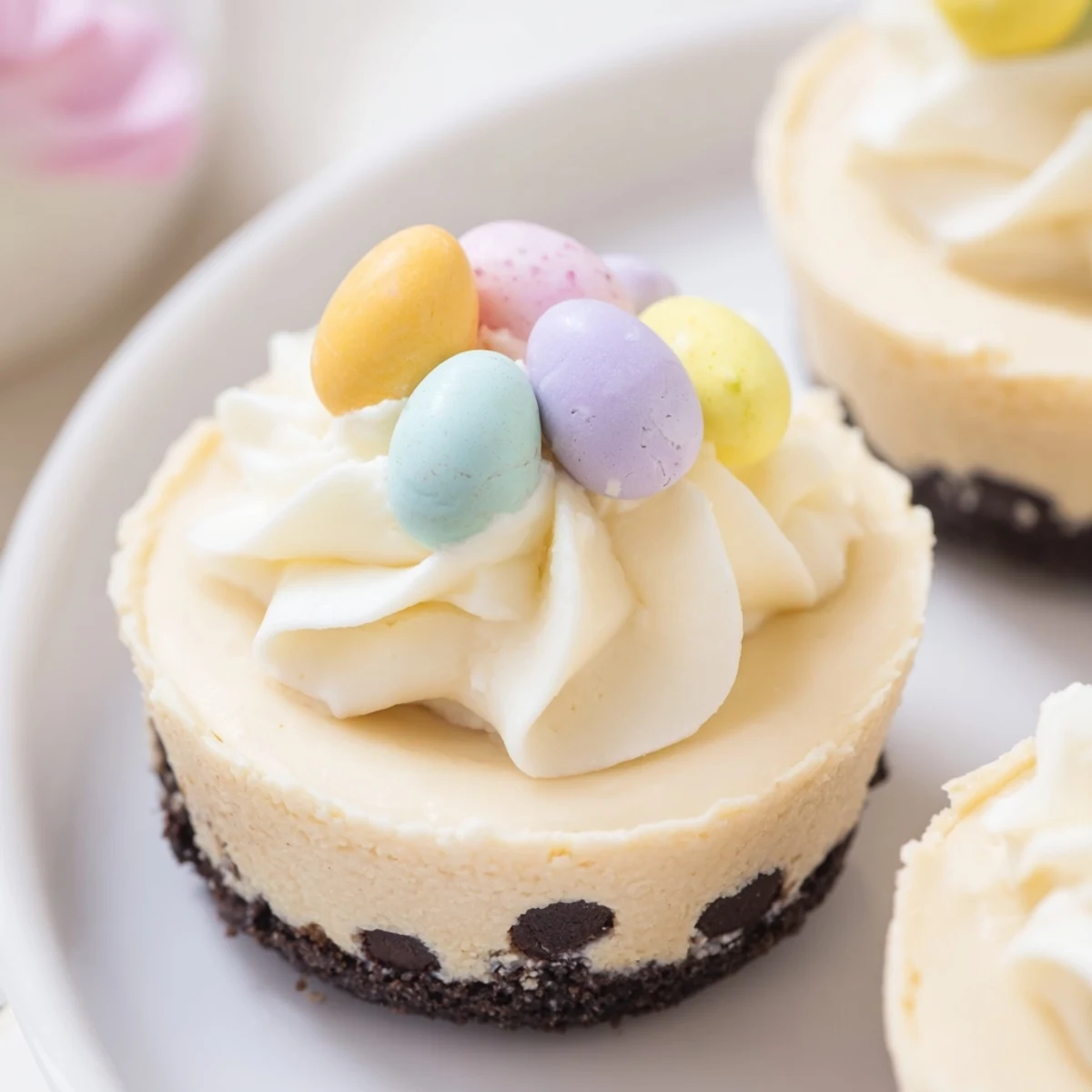 Individually portioned Easter Cadbury Mini Cheesecakes with smooth cream cheese filling and speckled chocolate candy toppings