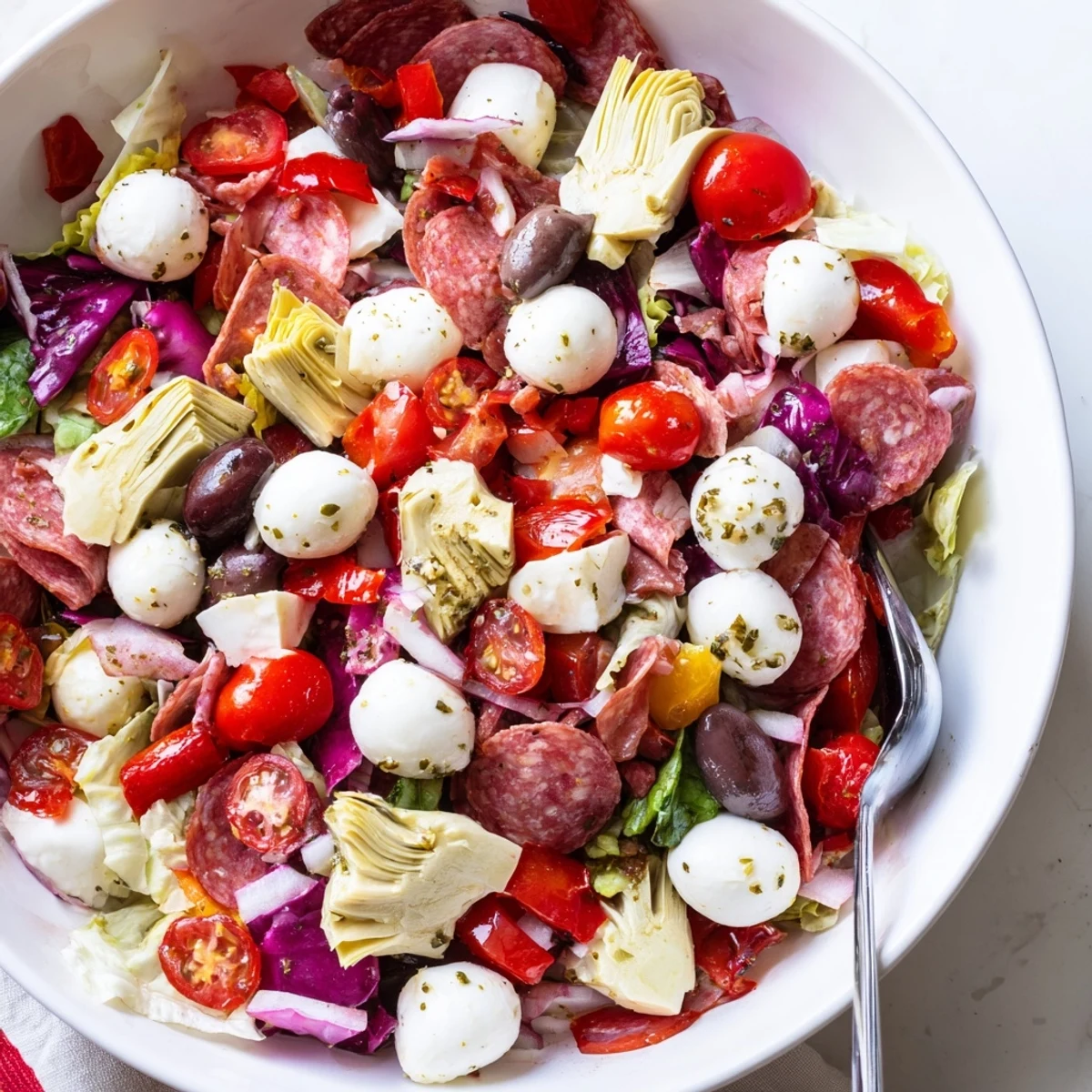 Italian antipasti chopped salad featuring romaine, artichokes, roasted peppers, and tangy dressing