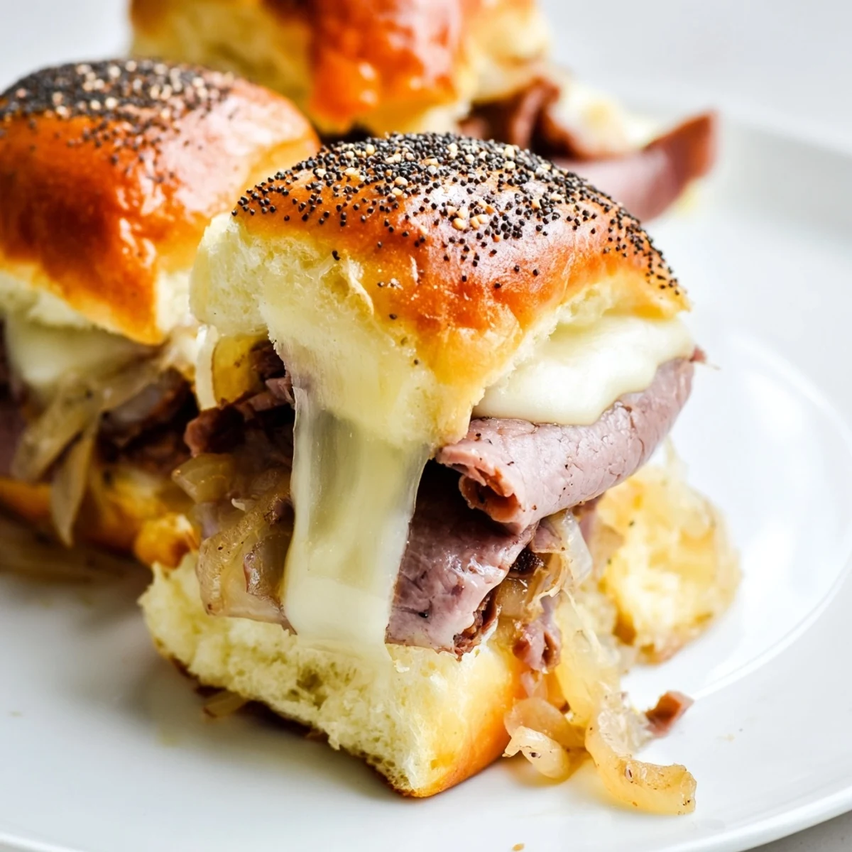 Melted provolone cheese drapes over tender beef in these savory French dip sliders
