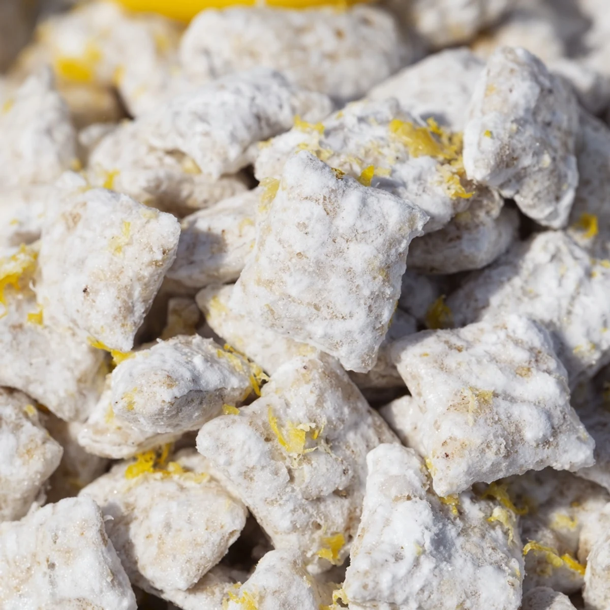 Refreshingly sweet lemonade puppy chow with zesty lemon swirls on a white serving platter
