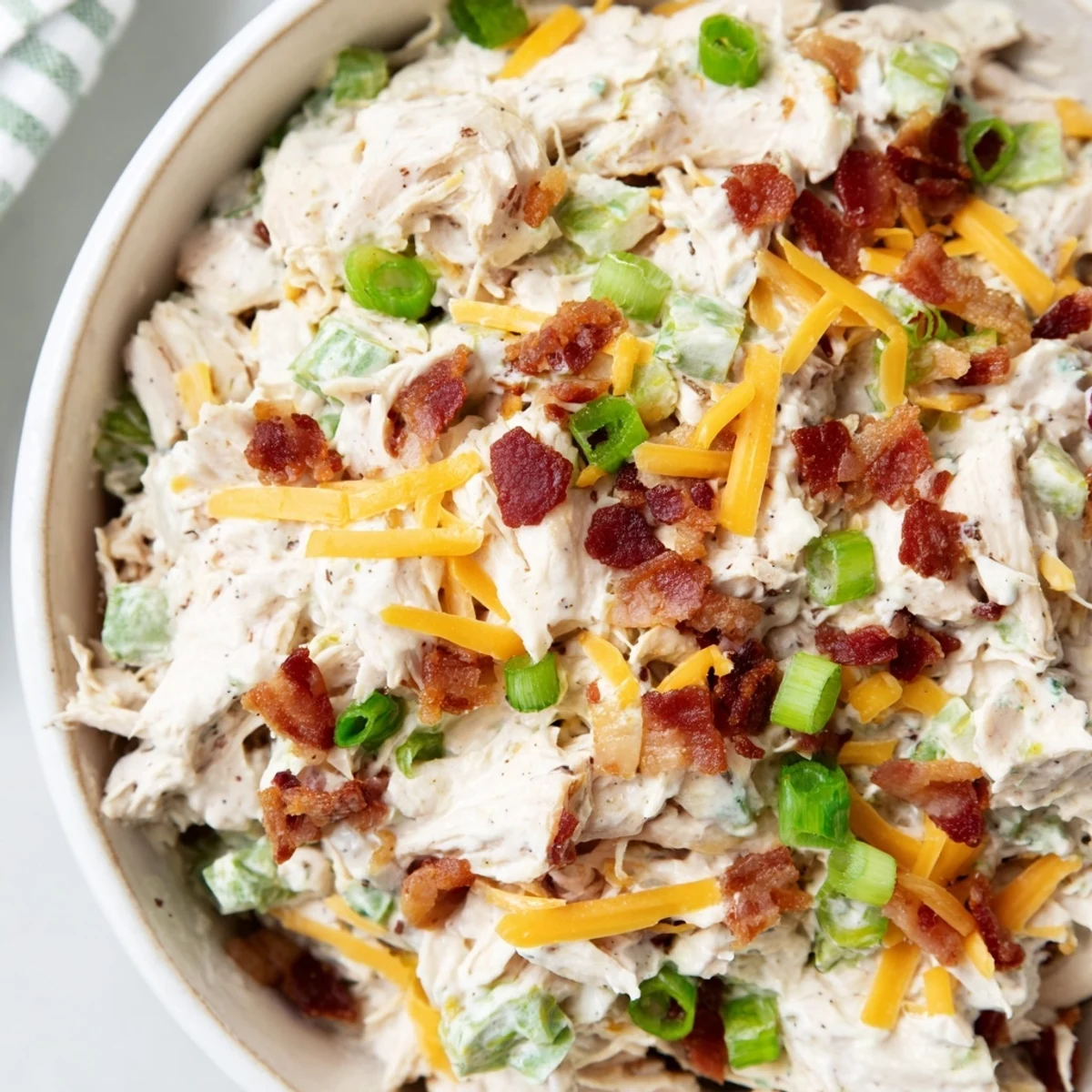 Spoonful of spicy low-carb chicken salad featuring diced jalapenos, crispy bacon crumbles, and shredded cheese