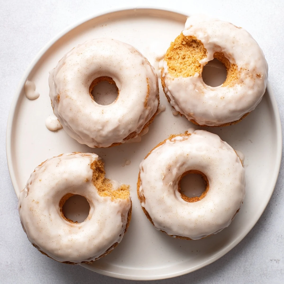 Fluffy Greek yogurt cake donuts with sweet glaze and cinnamon speckles, freshly baked