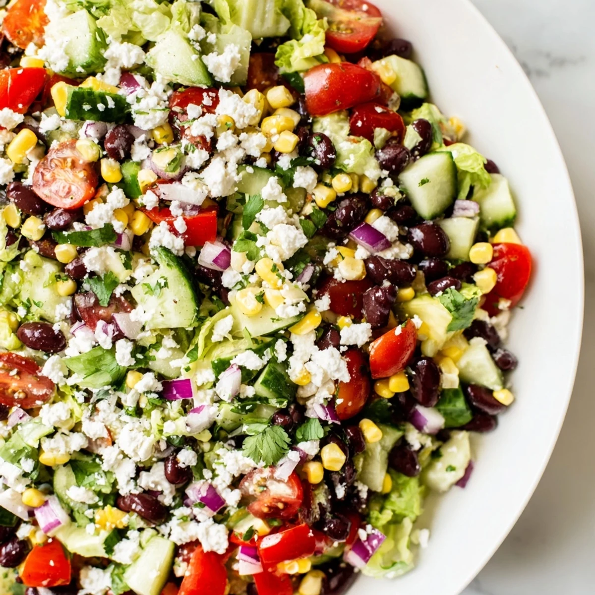 Colorful Mexican chopped salad in a white bowl with fresh vegetables and zesty lime cilantro dressing