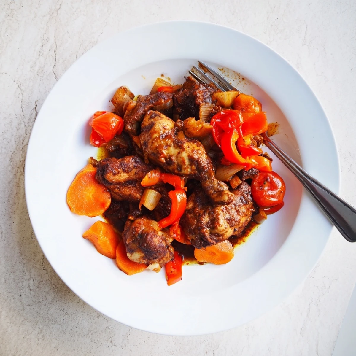 Golden seared Jamaican brown stew chicken served over fluffy white rice with thick savory sauce