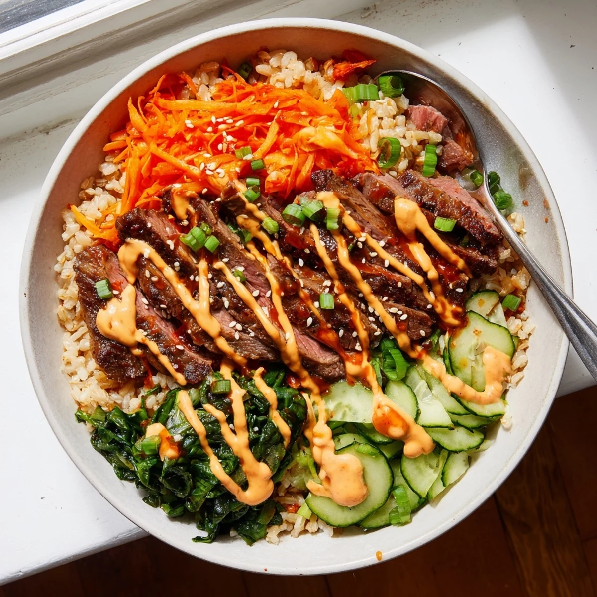 Caramelized Korean BBQ steak rice bowls drizzled with spicy cream sauce