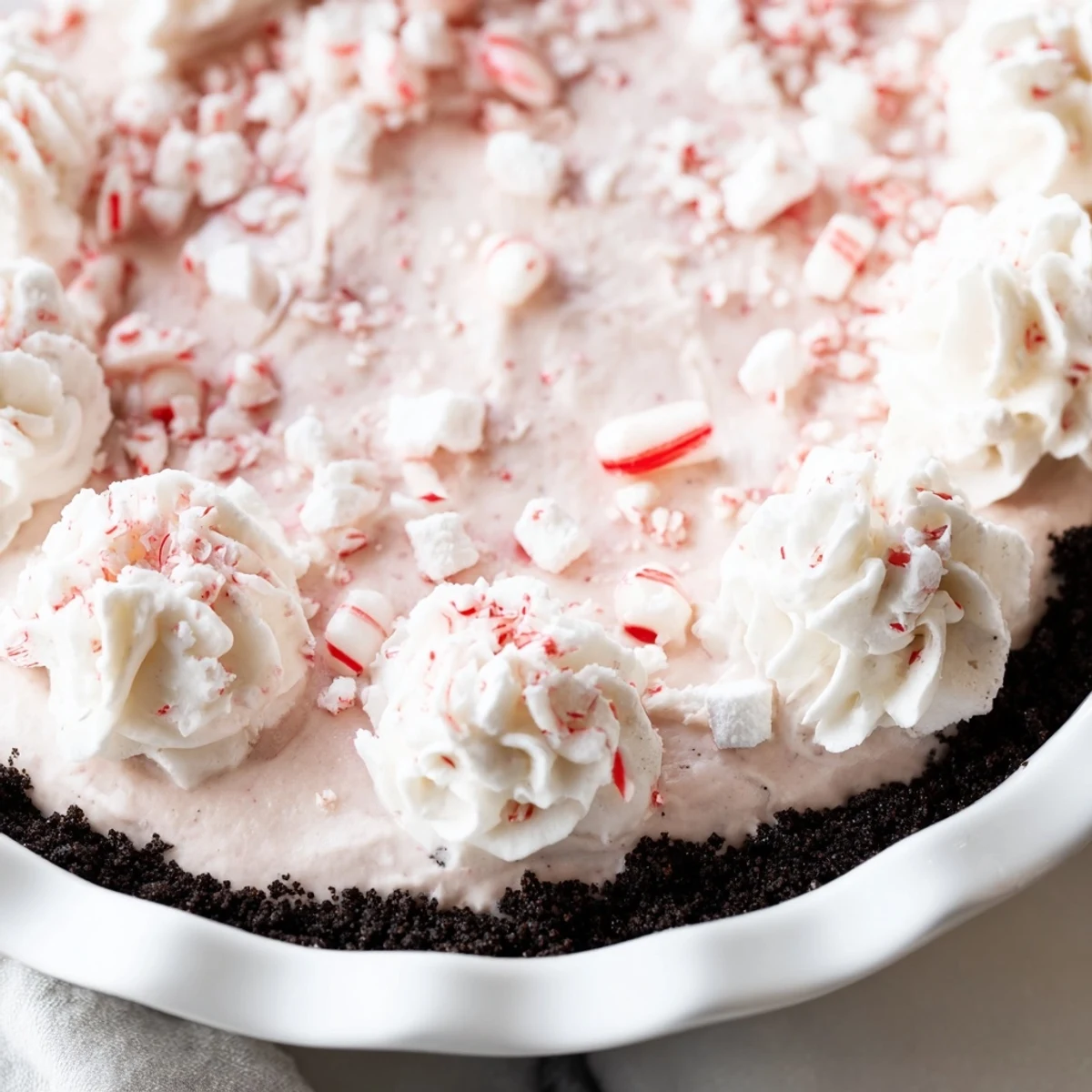Slice of Candy Cane Pie reveals fluffy peppermint cream and crunchy candy cane bits