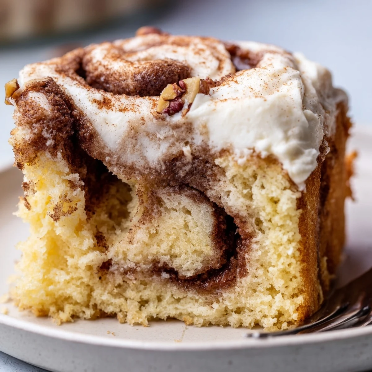 Warm Cinnamon Roll Poke Cake drizzled with cream cheese frosting, perfect for brunch  