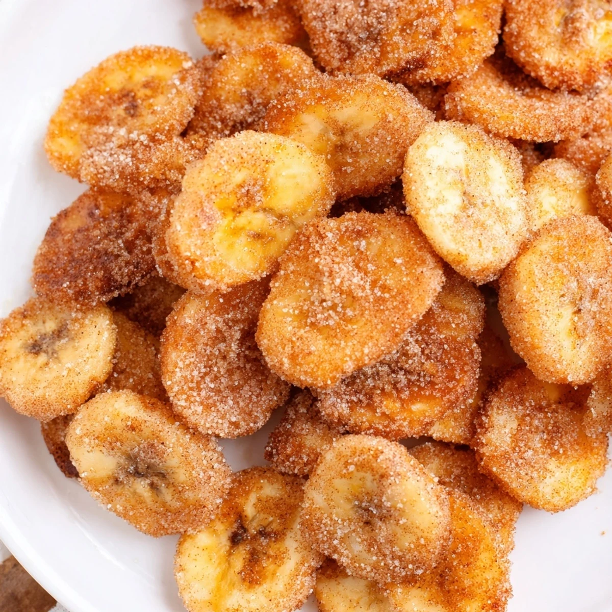 Snack bowl of Crispy Cinnamon Sugar Air Fryer Banana Chips beside coffee