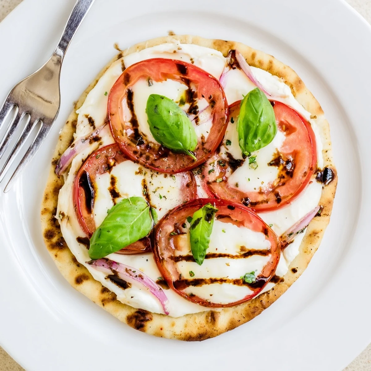 Warm Caprese Pita Pizza With Whipped Garlic Feta topped with basil