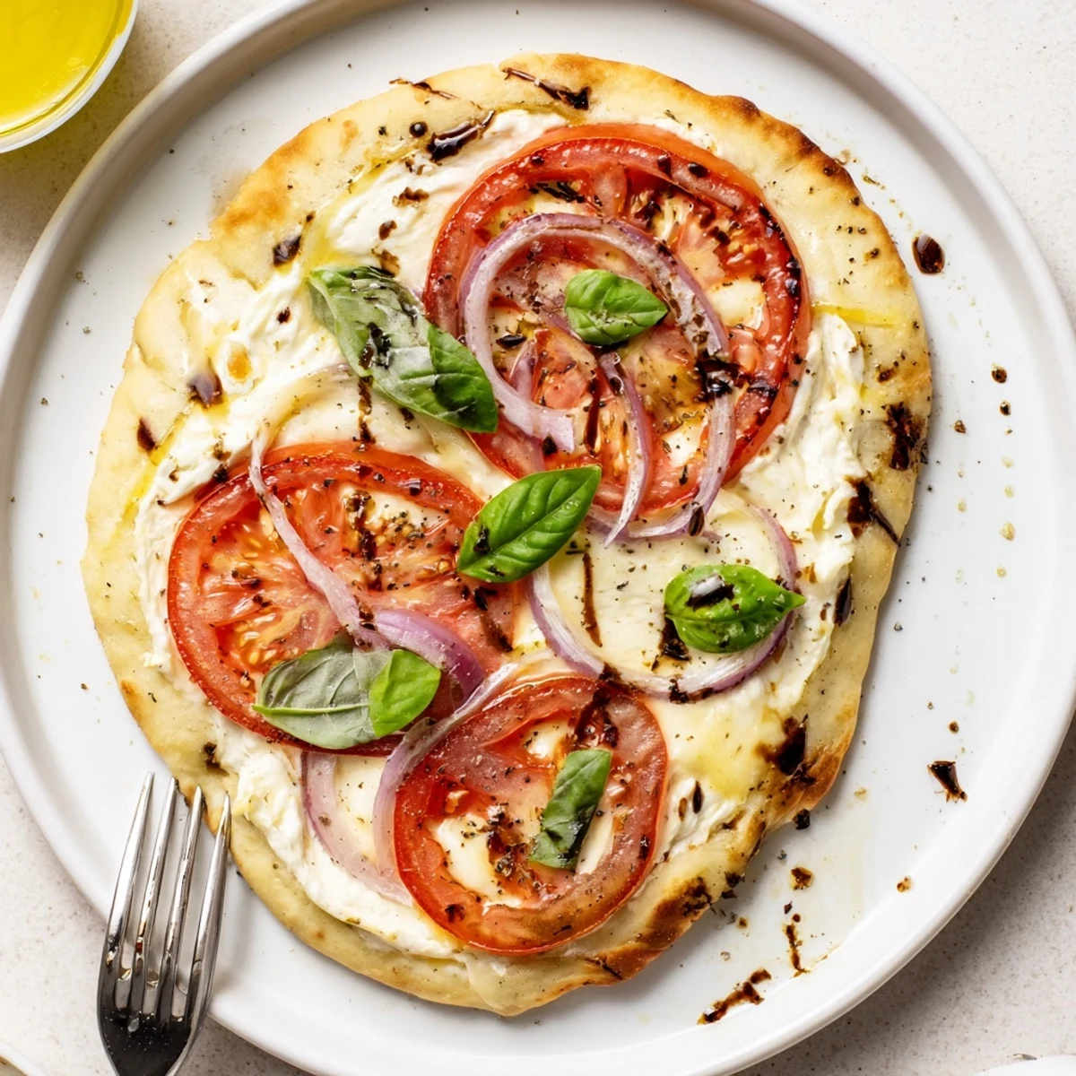 Sliced Caprese Pita Pizza With Whipped Garlic Feta drizzled with balsamic glaze