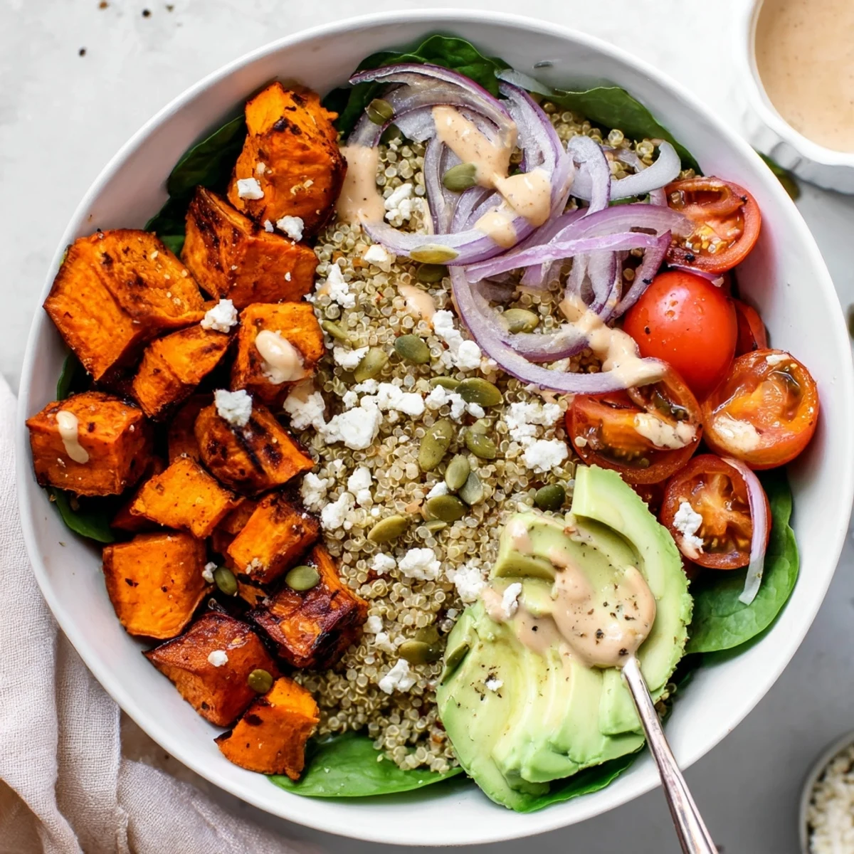 Bright Roasted Sweet Potato Quinoa Salad Bowl served warm over greens, creamy avocado