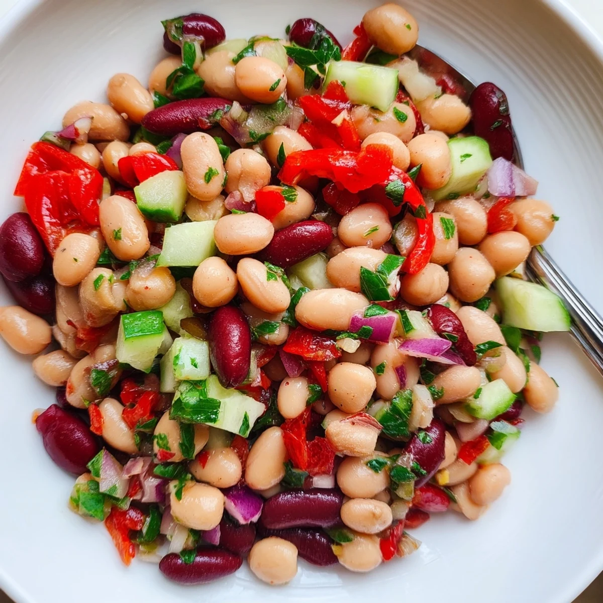 A bowl of Dense Bean Salad With Sun Dried Tomatoes, tangy and colorful
