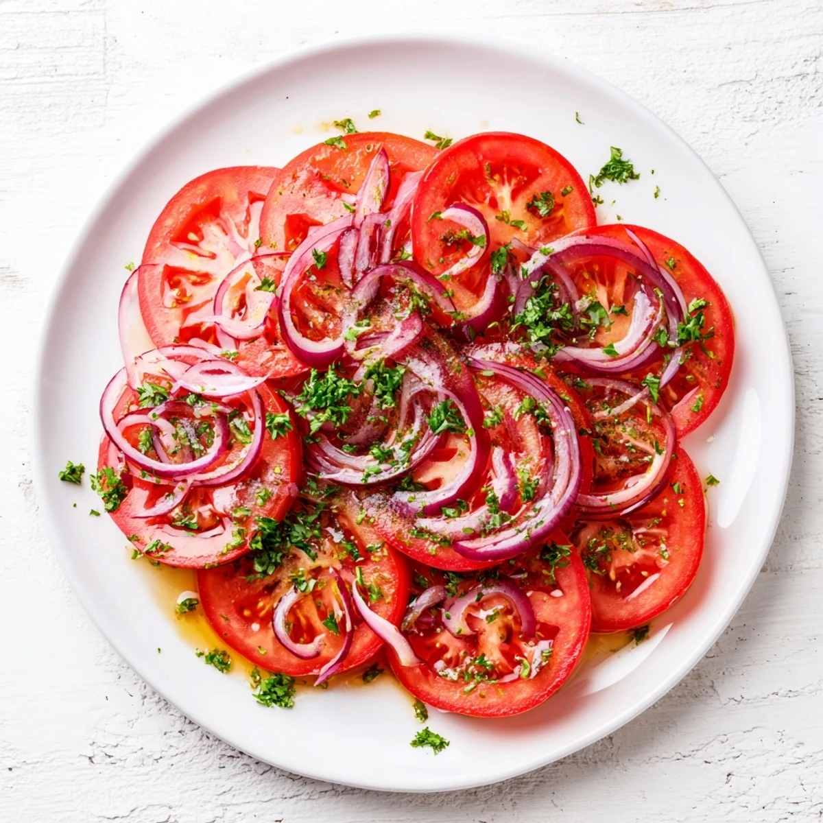 Fresh tomato and onion salad drizzled with olive oil vinaigrette and sprinkled with parsley