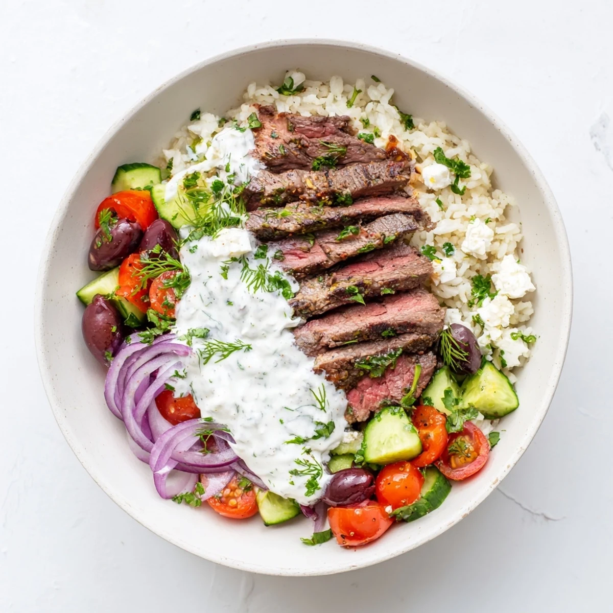 Juicy marinated steak served over fluffy lemon rice with crisp Mediterranean veggies and tangy Greek yogurt drizzle