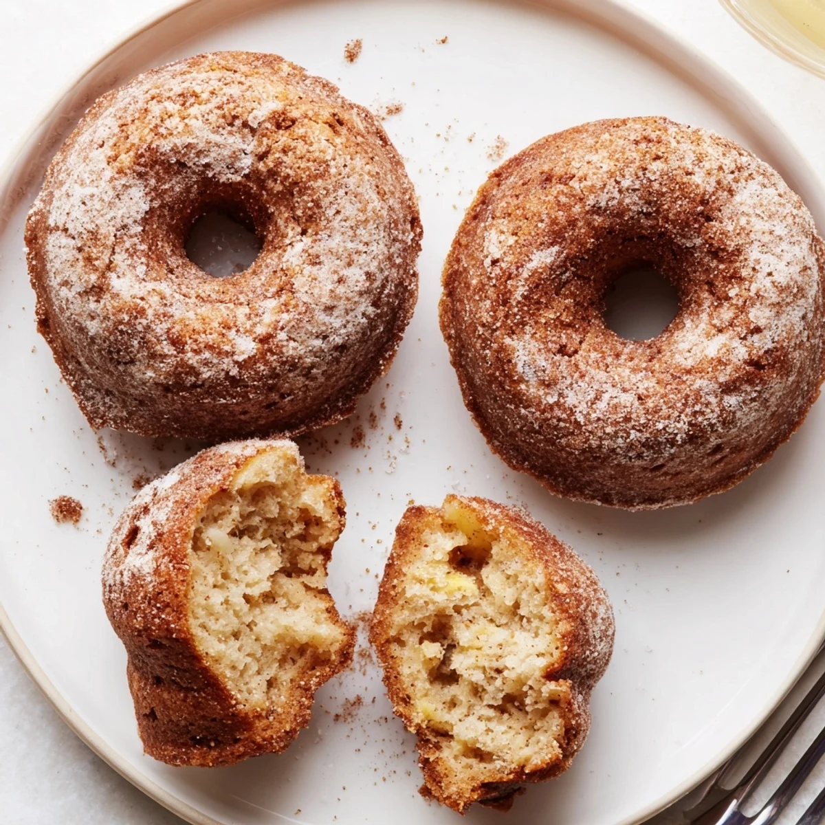 Stacked Banana Donuts on wire rack, dusted with cinnamon sugar, inviting