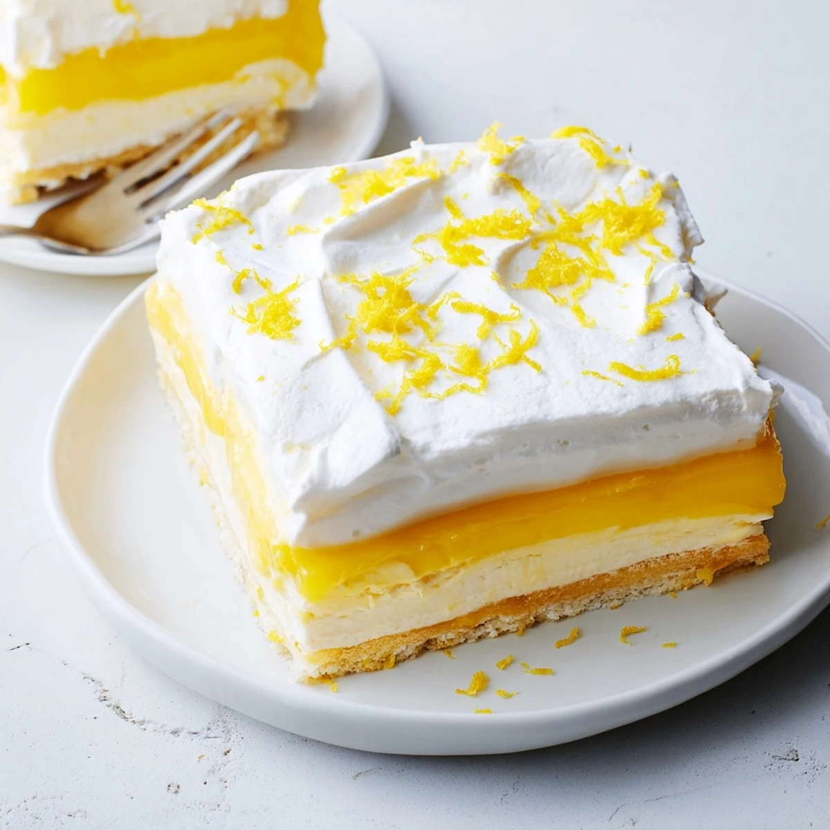 Creamy Lemon Lush Cake dessert in glass baking dish showing yellow lemon layer and white cream cheese filling