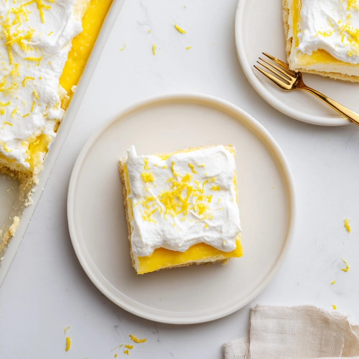 Lemon Lush Cake close-up slice with buttery crust, bright lemon pudding center, and billowy whipped topping