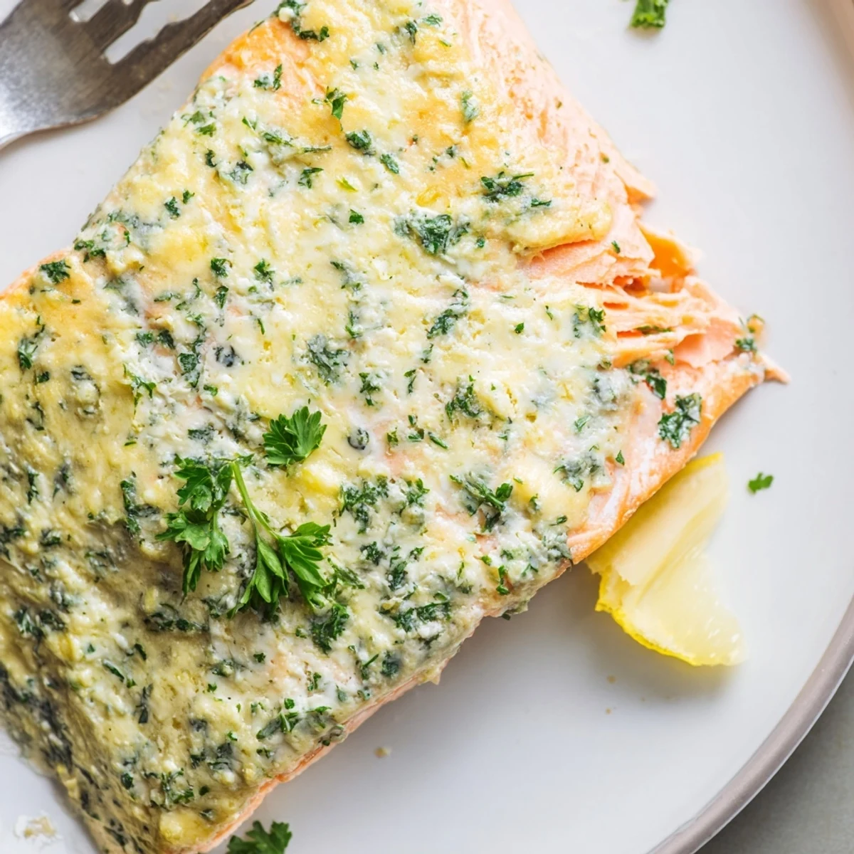 Tender baked salmon fillets topped with herbed Boursin cheese on parchment paper