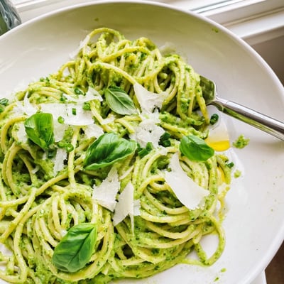 Bright herby green goddess pasta sauce topped with fresh basil and parmesan
